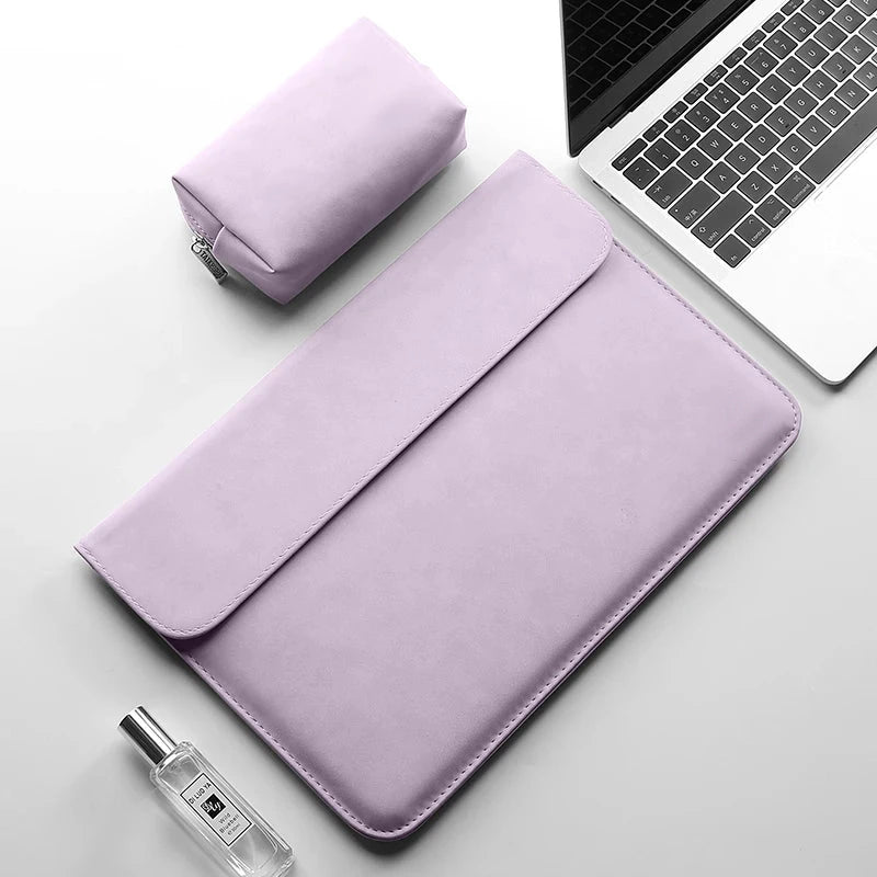 Pochette ordinateur mauve en simili cuir vue de dessus, rabat fermé et surpiqûre apparente, posée près de sa trousse assortie et d'un ordinateur portable.