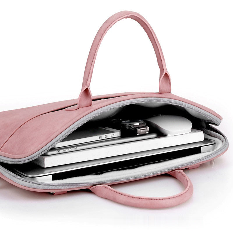 Sacoche pour ordinateur portable rose ouverte, garnie d'un ordinateur portable, d'une tablette, d'un téléphone et d'une souris blanche.